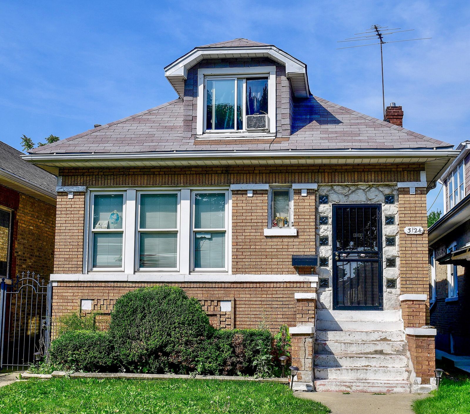 Brick Chicago bungalow on North Kilbourn Avenue with a hipped roof and front dormer