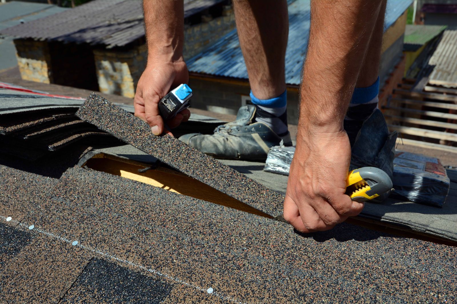 Hands fitting an architectural shingle into a course on a roof